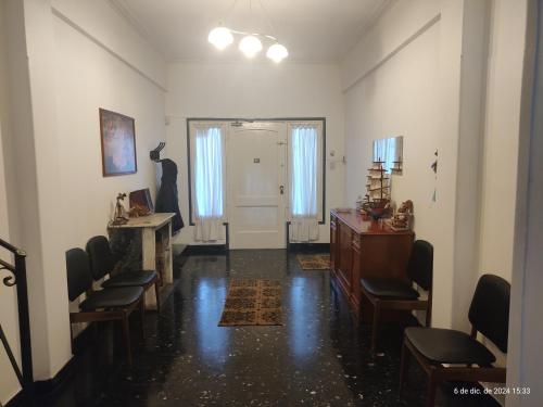 ein Wohnzimmer mit Stühlen, einem Tisch und einer Tür in der Unterkunft CIUDAD AUTONOMA DE BUENOS AIRES, HOSTAL , Habitacion en vivienda familiar in Buenos Aires