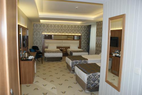 a hotel room with two beds and a television at Carmine Otel in Kırıkkale