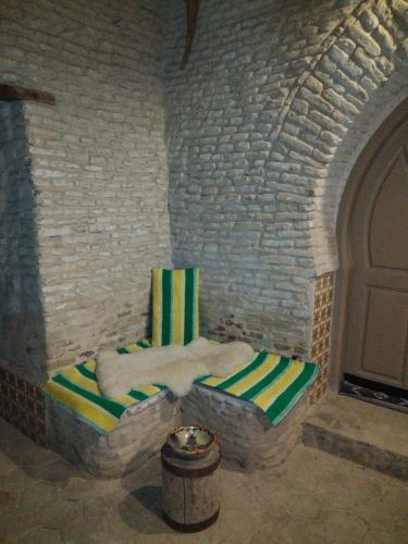 a room with a chair in a brick wall at Houch El Houdou in Tozeur