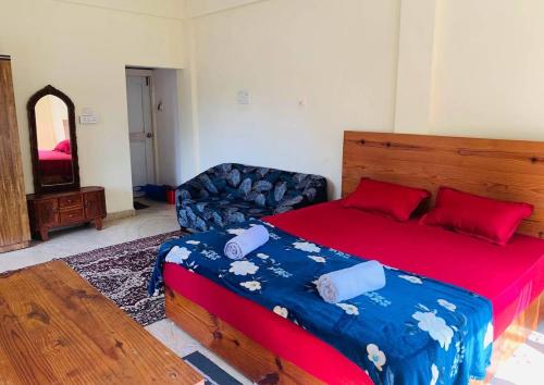 a bedroom with a large bed and a couch at The Bodhi Tree Resort in Morjim