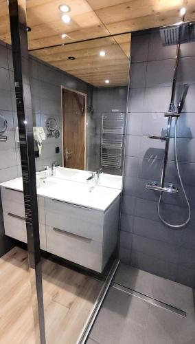 une salle de bain avec un lavabo blanc et une douche dans l'établissement Résidence Cry De Lys - Appartement entièrement rénové, au pied des pistes MAE-8451, aux Gets