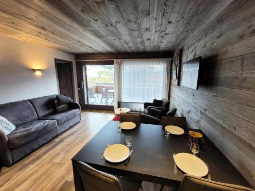 un salon avec une table et un canapé dans l'établissement Résidence Cry De Lys - Appartement centre station, proche des pistes MAE-8471, aux Gets