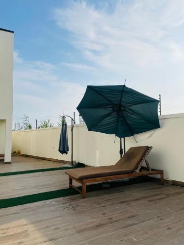 a bench with an umbrella on a roof at 3 bedroom villa, off Harris Drive VGC Lagos in Lagos