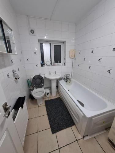 a bathroom with a tub and a toilet and a sink at Sam House in Portadown
