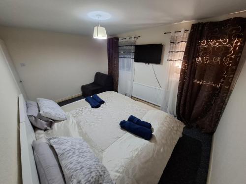 a bedroom with a bed with blue pillows on it at Sam House in Portadown