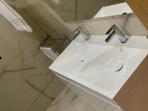 a white bathroom with a sink and a mirror at Garden Hill Villa Durres in Durrës