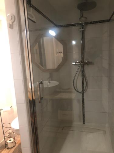 une salle de bain avec une douche avec une porte vitrée dans l'établissement Agréable studio 4 personnes RDC 5min à pieds du centre, des remontées et des thermes, à Cauterets