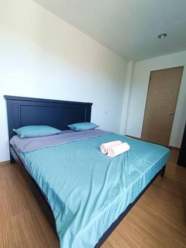 a bed with two towels on top of it at VI Homelite Resort in Miri
