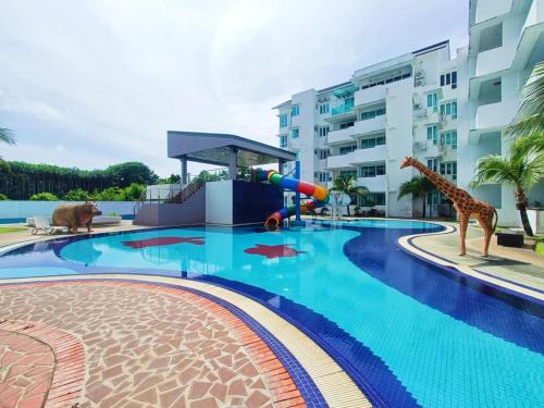 a swimming pool with a giraffe and a playground at VI Homelite Resort in Miri