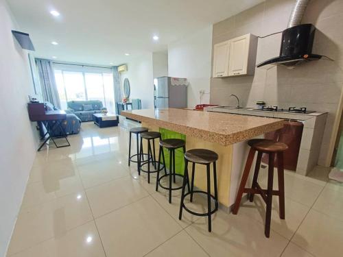 a kitchen with a counter and bar stools in a room at VI Homelite Resort in Miri
