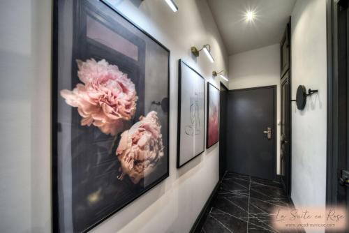 a hallway with framed pictures on the wall at La Suite en Rose - Spa - Lyon Centre Brotteaux in Lyon