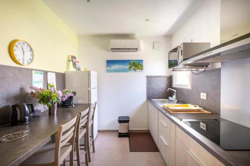 une cuisine avec un comptoir et une horloge au mur dans l'établissement Logement 2 chambres tout confort Nimes, à Nîmes