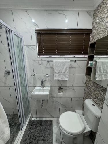 a bathroom with a toilet and a sink at Durban Holiday Apartments by Mieli Estates , Unit 4 in Durban