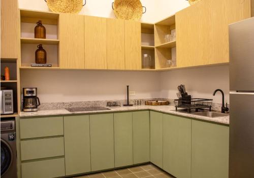 a kitchen with green cabinets and a sink at Casa Santa Ana Centro Mérida in Mérida