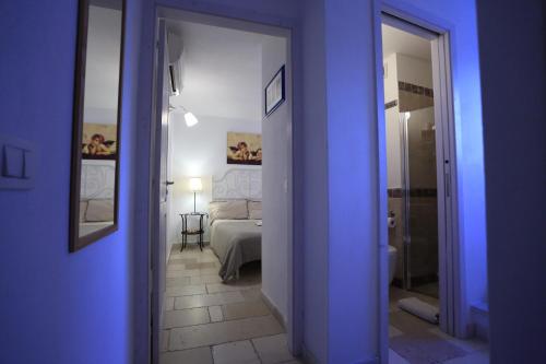 Habitación azul con dormitorio con cama y espejo. en La Casetta Nel Vico, en Polignano a Mare