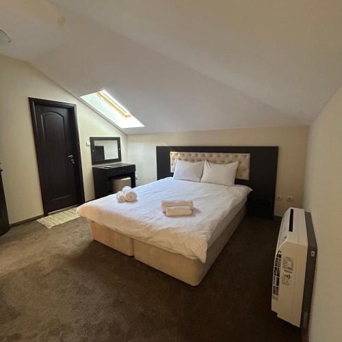 a bedroom with a large bed with two towels on it at Геша Форест in Dryanovo