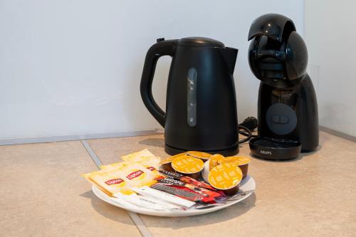 a plate of food next to a tea kettle at Tabelowa Deluxe Apartament with Garden in Łódź