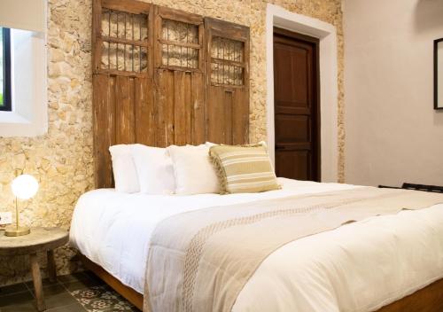 a bedroom with a large bed with a wooden headboard at Casa Santa Ana Centro Mérida in Mérida