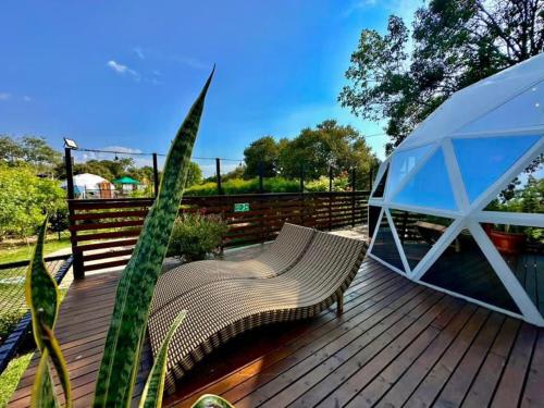 a wooden deck with a bench and a tent at Glamping Girardot & Hotel Puerta Del Sol Girardot in La Virginia