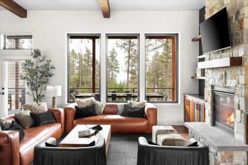 a living room with leather furniture and a fireplace at Luxe Lakeside New Build by Flathead Lake Speakeasy in Somers