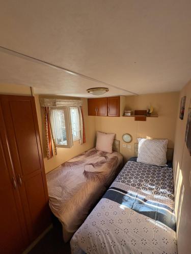 - une petite chambre avec 2 lits dans une caravane dans l'établissement Charmant mobilhome lac et montagnes remontées ski Morillon, à Verchaix