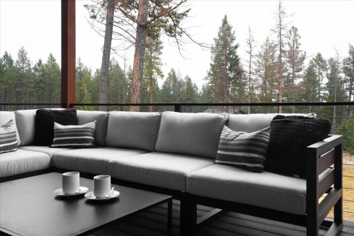 a white couch sitting on a porch with a table at Luxe Lakeside New Build by Flathead Lake Speakeasy in Somers