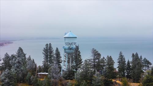 a water tower with the word serve on top of trees at Luxe Lakeside New Build by Flathead Lake Speakeasy in Somers