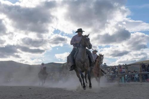 a group of men riding horses in the dirt at Luxe Lakeside New Build by Flathead Lake Speakeasy in Somers