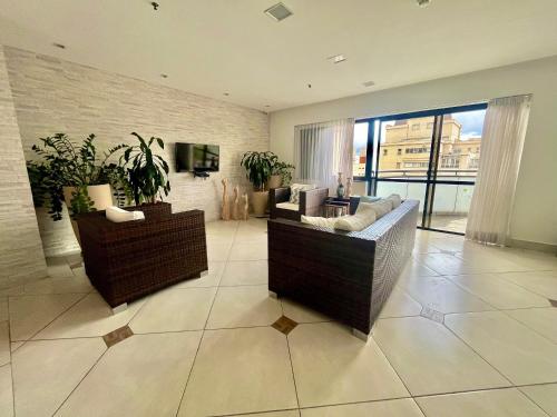 a living room with a couch and a tv at LFlats Hotel Alameda Lorena Jardins in Sao Paulo