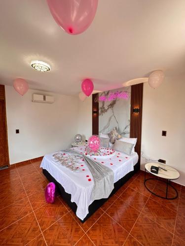 a bedroom with a large bed with pink balloons on it at Glamping Girardot & Hotel Puerta Del Sol Girardot in La Virginia
