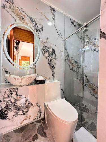 a bathroom with a toilet and a mirror at Glamping Girardot & Hotel Puerta Del Sol Girardot in La Virginia