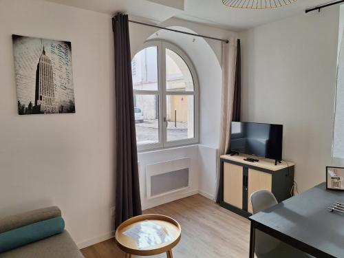 un salon avec une fenêtre et un canapé dans l'établissement Notre Dame 1 - Vue sur la Loire - Rdc - Hypercentre, à Orléans