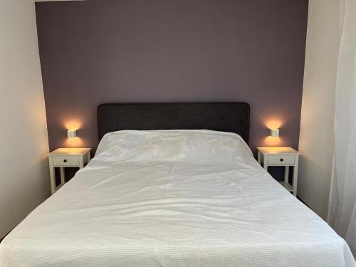 a bedroom with a bed with two lamps on both sides at REST - Ferienwohnung "Sonnenblume" mit schönem Bergpanorama - ab Mai Chiemgaukarte NEU! in Siegsdorf
