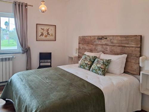 a bedroom with a large bed with two pillows at Quinta do Mastim in Évora