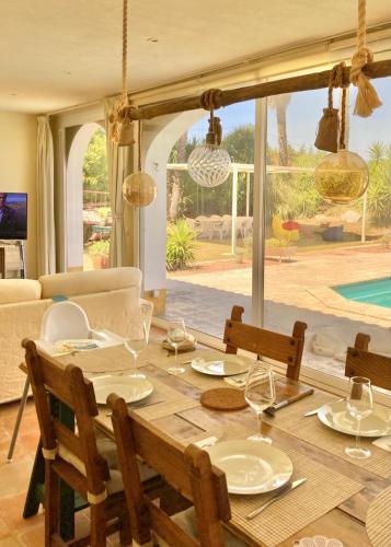 a dining room table with chairs and a view of a pool at Quinta do Mastim in Évora