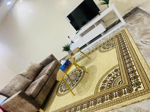a living room with a large rug and a television at RESIDENCE EL HADJI in Dakar