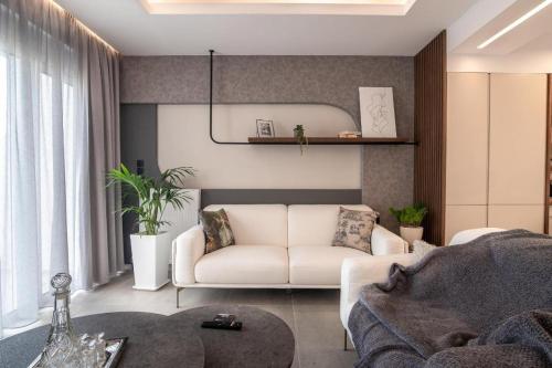 a living room with a white couch and a table at Calma Holiday House in Atsipopoulo