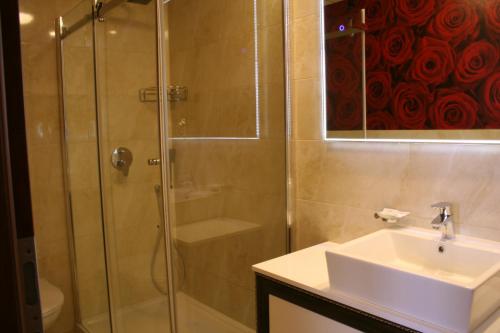 a bathroom with a glass shower and a sink at Golden Ball Club in Győr