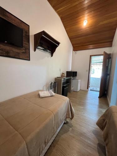 a bedroom with a bed and a television in a room at Familien Haus Pousada in Pomerode