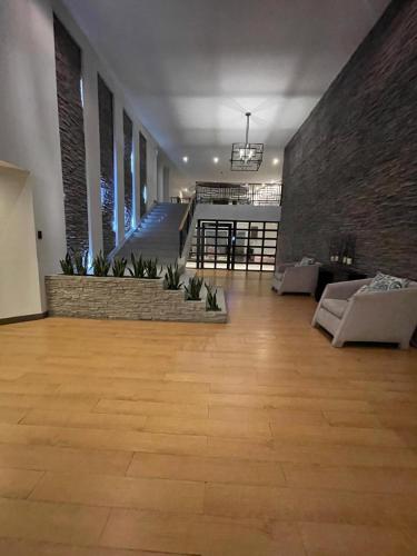 a large room with a wooden floor and a staircase at Penthouse lujo, Parque La Carolina, Piscina, parqueo 3 habitaciones in Quito