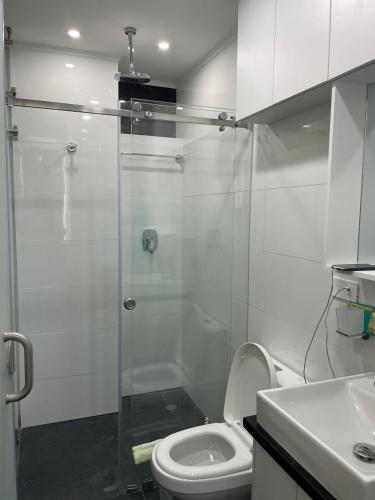 a bathroom with a toilet and a glass shower at Penthouse lujo, Parque La Carolina, Piscina, parqueo 3 habitaciones in Quito