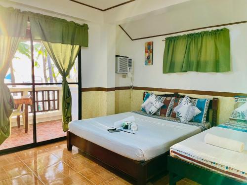 a bedroom with a bed and a couch and a balcony at Casa Fiesta Resort in Boracay