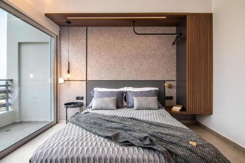 a bedroom with a large bed with a large window at Calma Holiday House in Atsipopoulo