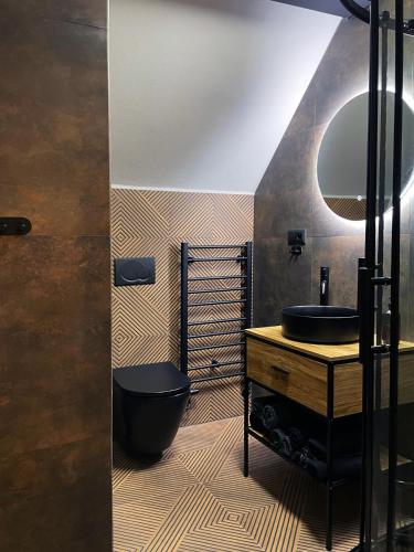 a bathroom with a black toilet and a sink at Penzion BOHEM centrum in Český Krumlov