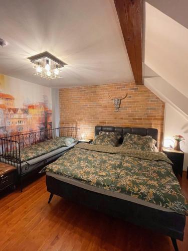 a bedroom with two beds and a brick wall at Penzion BOHEM centrum in Český Krumlov
