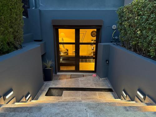 a blue building with a glass door and stairs at Luxury StudioArchit 7 & jacuzzi suite in Patra