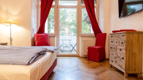 a bedroom with a bed and a dresser and a window at Bolzano Rooms in Bolzano
