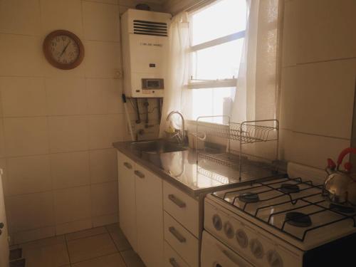a kitchen with a stove and a sink and a window at Cuatro Estaciones in San Carlos de Bariloche