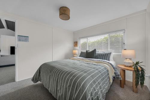 a white bedroom with a bed and a window at Settlers Cottage and Settle Inn in Broadwater