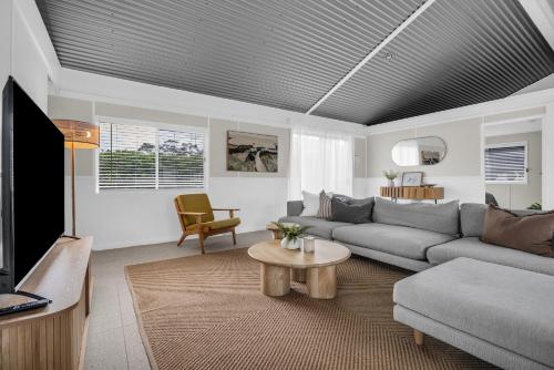 a living room with a couch and a tv at Settlers Cottage and Settle Inn in Broadwater